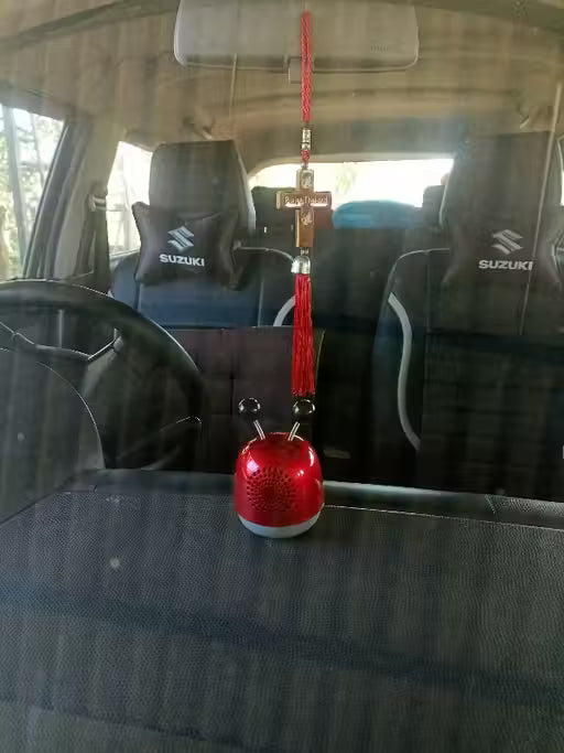 Mini Robot Car Perfume-Red car hanging ornament with cross on a car seat inside a vehicle.