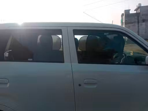 Window Sun Shade-Car interior with a person sitting inside, sun shining through the window