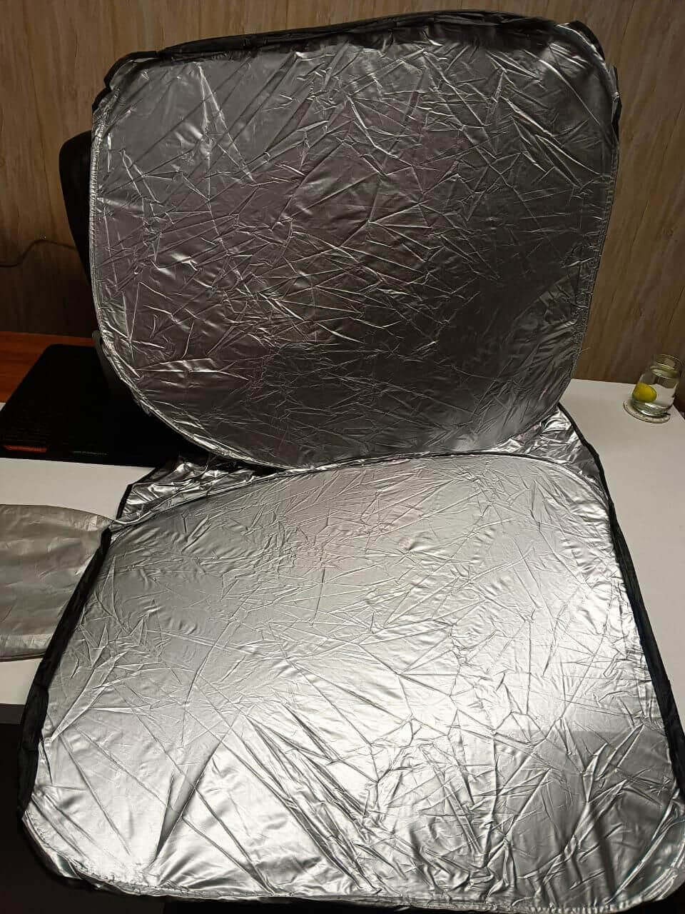 Foldable silver car window sunshade cover designed to block UV rays and cool the interior.