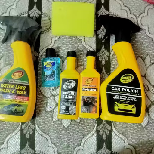 Collection of car care products including bottles and a spray bottle on a patterned surface.